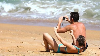 Пара на пляже с фотоаппаратом